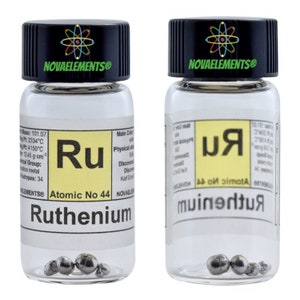 Op de afbeelding: Twee doorzichtige glazen flesjes met zwarte deksels die kleine stukjes rutheniummetaal bevatten. De flesjes zijn gelabeld met de naam van het element, het atoomnummer en andere eigenschappen. De labels zijn geel met zwarte tekst. De flesjes staan op een witte achtergrond.