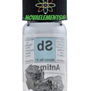 Pu&ograve; includere: Un piccolo flacone di vetro con un tappo nero che contiene un campione di Antimonio, un metalloide grigio argenteo. L'etichetta sul flacone riporta "Antimonio" e "Numero atomico 51" con il simbolo chimico "Sb". Il flacone ha un logo Novaelements sul tappo.