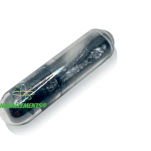 Puede incluir: Un tubo de vidrio transparente que contiene una pequeña cantidad de metal gris plateado. El tubo está etiquetado con "NOVAELEMENTS®" y tiene un pequeño símbolo atómico en su interior.