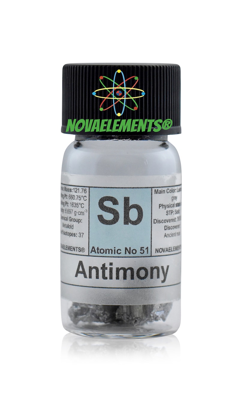 Pu&ograve; includere: Un piccolo flacone di vetro contenente un campione di antimonio, un elemento metalloide. Il flacone ha un tappo nero con il testo "NOVAELEMENTS&reg;" e un simbolo di atomo stilizzato. L'etichetta sul flacone include il simbolo dell'elemento "Sb", il numero atomico 51 e il nome "Antimonio".