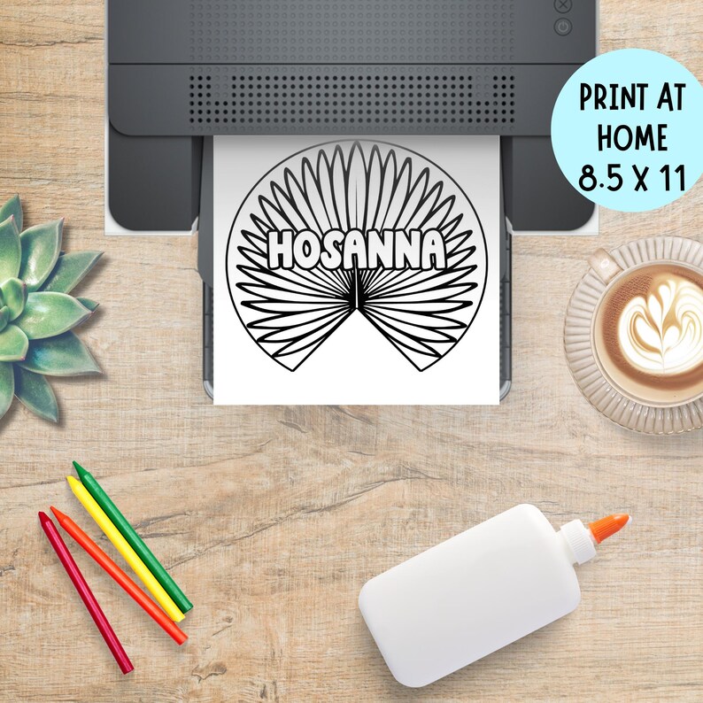 May include: A black and white "Hosanna" printable design is being printed from a printer. The design is on an 8.5 x 11 inch sheet of paper. The image also includes crayons, glue, and a cup of coffee.