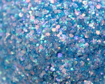 May include: Close-up of a pile of light blue glitter with iridescent flecks. The glitter appears to be a mix of different shapes and sizes, creating a sparkling effect. The overall theme is craft supplies.