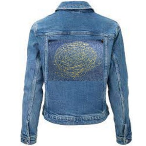 Op de afbeelding: Een blauwe denimjas met een geel geborduurd ontwerp op de rug. Het ontwerp is een cirkelvormig patroon van lijnen en swirls.
