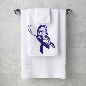 Peut inclure: Serviette de bain blanche avec un motif de papillon violet avec un ruban. Le papillon est en vol, les ailes déployées.