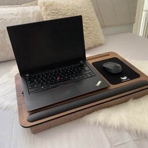 Może przedstawiać: Drewniany stojak na laptopa z wbudowanym podparciem nadgarstka i czarną podkładką pod mysz z nadrukiem "AGOLR". Na stojaku znajduje się laptop i bezprzewodowa mysz.