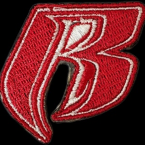 May include: Red embroidered iron-on patch with a stylised white letter "R" in the centre.