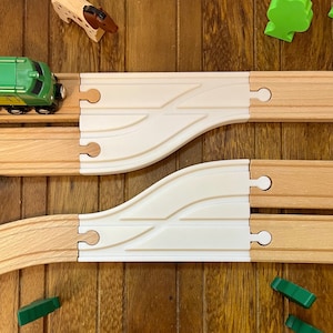 May include: Two wooden train track pieces with white plastic inserts. The track pieces are curved and connect to create a continuous track.