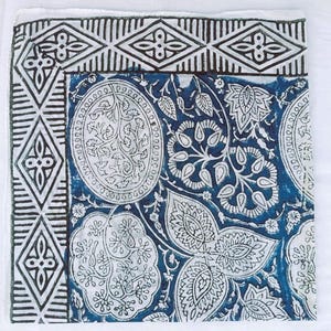 K&ouml;nnte beinhalten: Quadratischer Stoff mit einem indigoblauen und wei&szlig;en Muster. Das Design umfasst einen Rand mit geometrischen Diamant- und Linienmustern. Das zentrale Design zeigt gro&szlig;e, stilisierte Blumen- und Blattmotive in Wei&szlig; auf blauem Hintergrund.