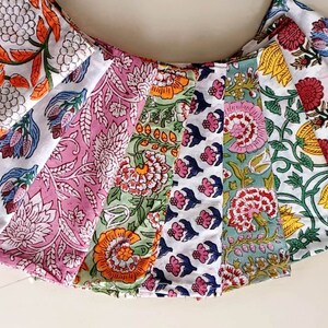May include: A set of eight fabric squares with floral patterns in various colors, including pink, green, blue, orange, and white. The fabric squares are arranged in a fan shape.