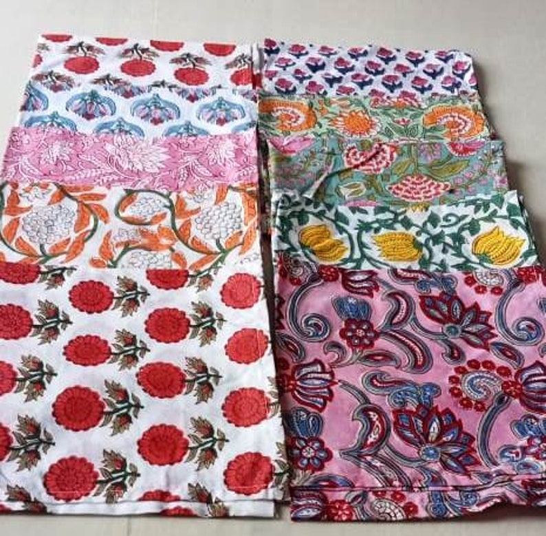 May include: A set of ten colorful fabric napkins with floral patterns. The napkins are made of cotton and are perfect for adding a touch of elegance to any table setting.