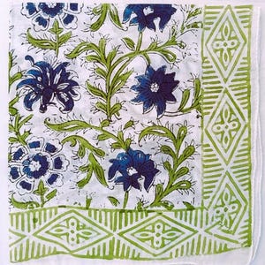 K&ouml;nnte beinhalten: Wei&szlig;er Stoff mit einem sich wiederholenden Muster aus blauen Blumen und gr&uuml;nen Ranken. Ein gr&uuml;ner geometrischer Rand rahmt den Rand ein. Das florale Design ist im Blockdruckverfahren hergestellt, wodurch eine strukturierte Optik entsteht. Die Gesamt&auml;sthetik erinnert an ein Vintage-Textil.