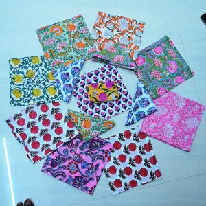 May include: A set of ten colorful fabric squares with floral and geometric patterns. The squares are made of cotton and are perfect for crafting, quilting, or home decor.