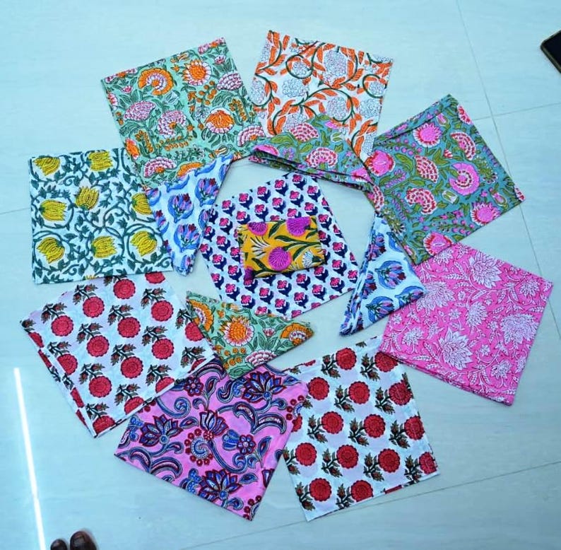 May include: A set of ten colorful fabric squares with floral and geometric patterns. The squares are made of cotton and are perfect for crafting, quilting, or home decor.