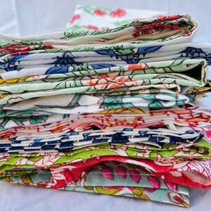 May include: A stack of colorful fabric napkins with floral patterns. The napkins are folded and stacked on top of each other, creating a layered effect. The napkins are made of cotton and have a soft, comfortable feel.