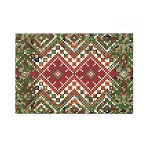 Pode incluir: Têxtil retangular com um padrão geométrico. O design apresenta uma forma de diamante vermelho central, rodeada por detalhes pixelizados brancos, verdes, laranja e castanhos. O fundo tem um padrão tipo camuflagem.