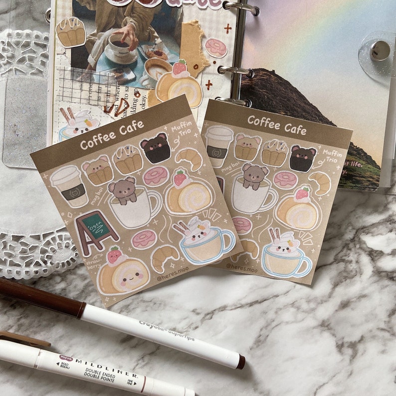 May include: Two sheets of stickers with a coffee shop theme. The stickers feature illustrations of coffee cups, pastries, and bears. The text on the stickers reads "Coffee Cafe" and "Muffin Trio".