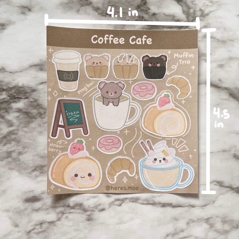 May include: A sheet of stickers featuring a coffee cafe theme with illustrations of coffee cups, pastries, and bears. The stickers are 4.1 inches wide and 4.5 inches tall. The text "Coffee Cafe" is at the top of the sheet. The text "Muffin Trio" is at the top right of the sheet. The text "mug boi" is at the top left of the sheet. The text "Open" is on a sign at the bottom left of the sheet. The text "straw-berry" is at the bottom left of the sheet. The text "@heres.moo" is at the bottom right of the sheet.