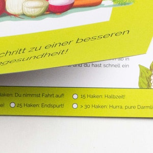 May include: A yellow card with a checklist for gut health. The checklist includes the following milestones: Start, 10 hooks: You're gaining momentum, 15 hooks: Halftime, 25 hooks: You're in the final stretch, and 30 hooks: You've reached your goal. The card is decorated with illustrations of vegetables.