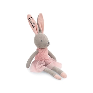 Könnte beinhalten: Eine graue und rosa gestrickte Hasenpuppe, die einen rosa Tüllrock trägt. Der Hase hat ein Namensschild am Ohr, auf dem "Emilia" steht.