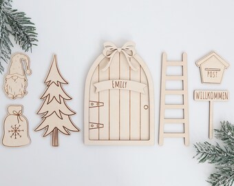 May include: Wooden craft kit for a fairy door with a personalized nameplate, a ladder, a tree, a gnome, a mailbox, and a sign that says "Willkommen".