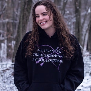 Marvel Hawkeye tv show hoodie inspired by Kate Bishop's quotes to Clint Barton, “All I Want Is Trick Arrows & A Cool Costume," with art of bow and arrows. Perfect merchandise or gift for a Marvel fan!