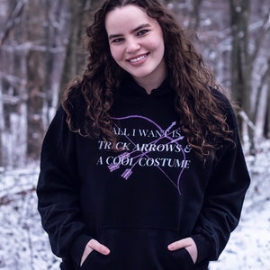 Marvel Hawkeye tv show hoodie inspired by Kate Bishop's quotes to Clint Barton, “All I Want Is Trick Arrows & A Cool Costume," with art of bow and arrows. Perfect merchandise or gift for a Marvel fan!