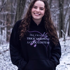 Marvel Hawkeye tv show hoodie inspired by Kate Bishop's quotes to Clint Barton, “All I Want Is Trick Arrows & A Cool Costume," with art of bow and arrows. Perfect merchandise or gift for a Marvel fan!