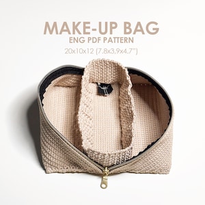 May include: A beige crocheted makeup bag with a gold zipper and black lining. The bag is open and the inside is visible. The bag is 20 inches by 10 inches by 12 inches (7.8 inches by 3 inches by 4.7 inches).