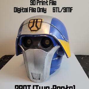 May include: A blue, silver, and yellow helmet with the text "3D Print File Digital File Only STL/3MF" and "280T (Two-Boots)". The helmet has two eye openings and a face guard. The top of the helmet is silver with a yellow and black emblem.