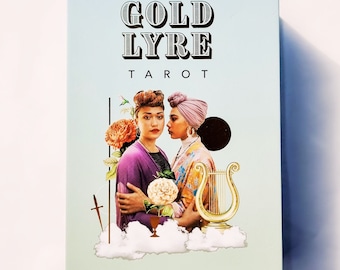 May include: A box for a tarot deck with the title "GOLD LYRE TAROT" in black text on a light blue background. The box features a collage of two women wearing colorful headbands, flowers, and a gold lyre.