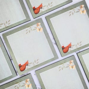 May include: Set of six green square sticky notes with a white background and a border. Each note features a small illustration of a fox and a butterfly.