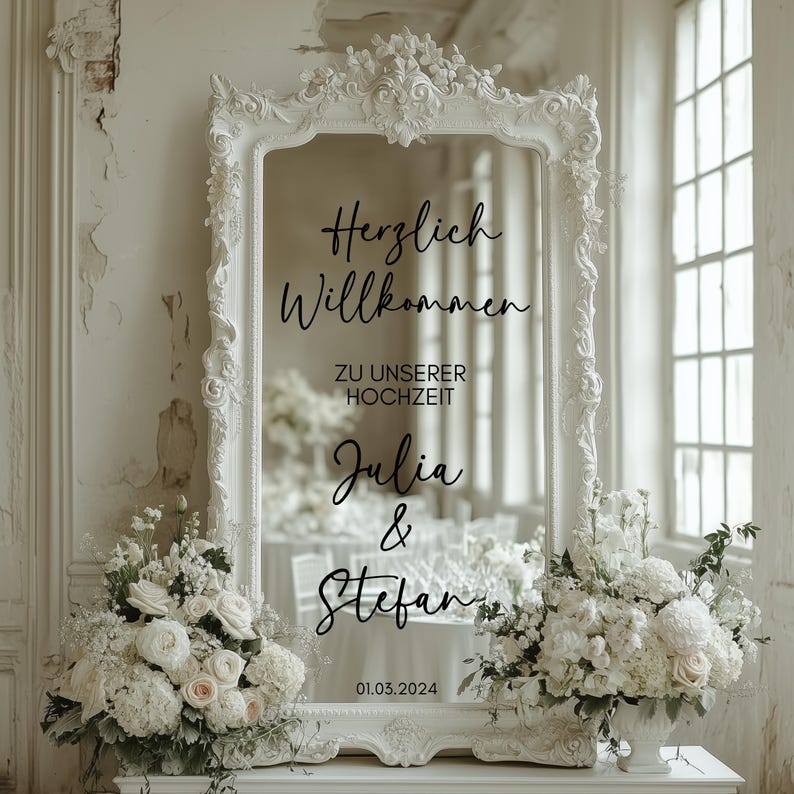 Peut inclure: Un miroir blanc orn&eacute; avec un autocollant en vinyle noir qui indique "Herzlich Willkommen zu unserer Hochzeit Julia & Stefan 01.03.2024". Le miroir est d&eacute;cor&eacute; de fleurs blanches.