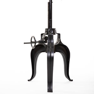 May include: Black metal table base with a height adjustment mechanism and three curved legs.