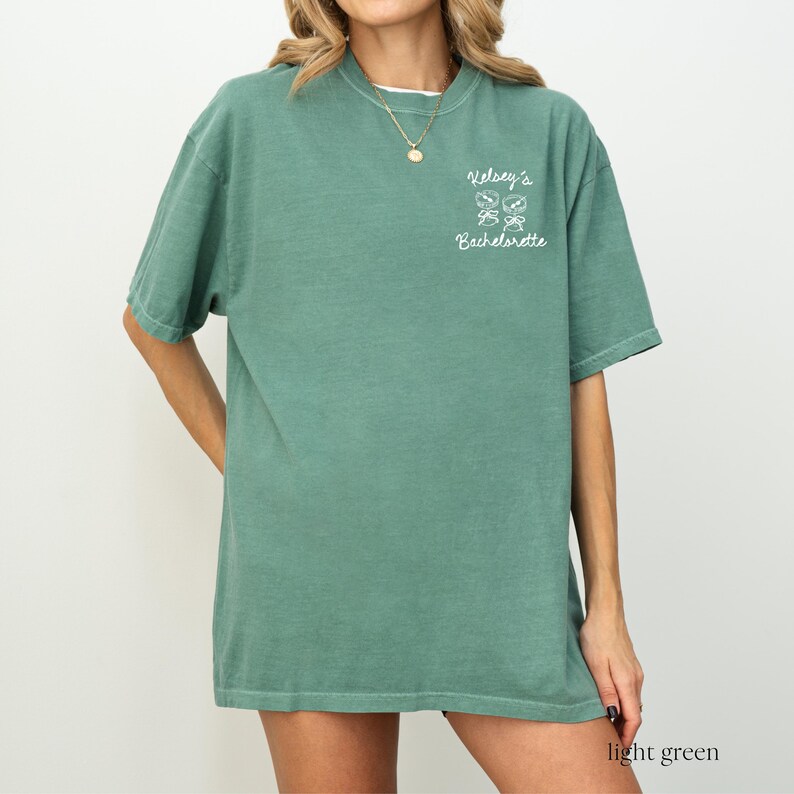 May include: Light green t-shirt with the text "Kelsey's Bachelorette" and a graphic of four shamrocks.