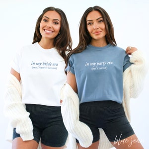 K&ouml;nnte beinhalten: Zwei Frauen tragen T-Shirts mit dem Text "in my bride era (mrs. conner's version)" und "in my party era (lexi's version)".