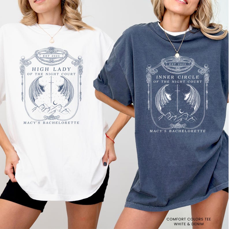 Op de afbeelding: Twee oversized T-shirts, &eacute;&eacute;n wit en &eacute;&eacute;n denimblauw, met een gedetailleerde afbeelding. De afbeelding bevat de tekst "HIGH LADY OF THE NIGHT COURT" en "INNER CIRCLE OF THE NIGHT COURT", een zwaard, vleugels en een bergontwerp. De tekst "MACY'S BACHELORETTE" is ook aanwezig.