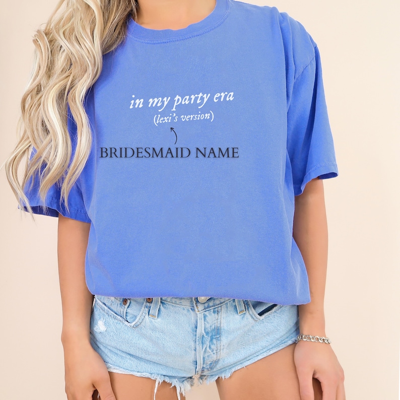 K&ouml;nnte beinhalten: Ein blaues T-Shirt mit dem Text "in my party era (lexi's version)" und "BRIDESMAID NAME" darauf gedruckt.