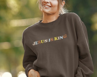 May include: A brown sweatshirt with the text "JESUS IS KING" in colorful letters.