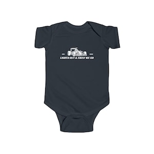 Könnte beinhalten: Dunkelmarinefarbener Baby-Body mit einer weißen Grafik eines Rennwagens und dem Text "EST. 1950 LIGHTS OUT & AWAY WE GO". Das einteilige Kleidungsstück ist aus weichem Stoff.