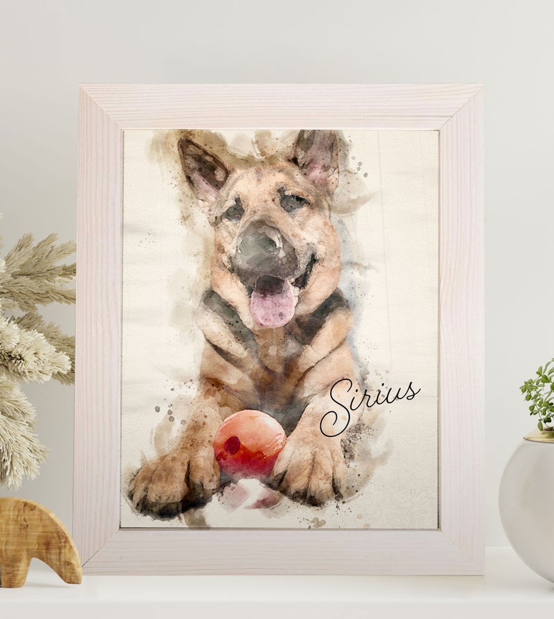 May include: Watercolor-style framed print of a German Shepherd puppy with a red ball. The dog is brown and black with its tongue out. The name "Sirius" is written in cursive. The frame is white.