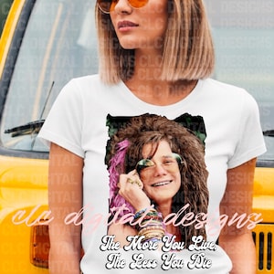 May include: White t-shirt featuring a portrait of Janis Joplin wearing sunglasses and jewelry. The text "The More You Live, The Less You Die" is below the image. The shirt is a classic crew neck.