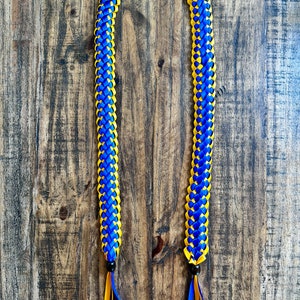 May include: A blue and yellow lei made of ribbon, with black beads at the ends.