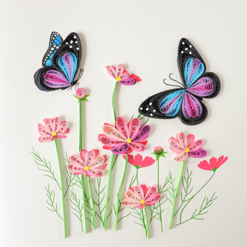May include: Paper craft of two butterflies with pink and blue wings and a field of pink cosmos flowers.