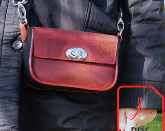 May include: A red leather crossbody bag with a black trim and a silver clasp. The bag has a small pocket on the front with the word "Nicky" embossed on it.