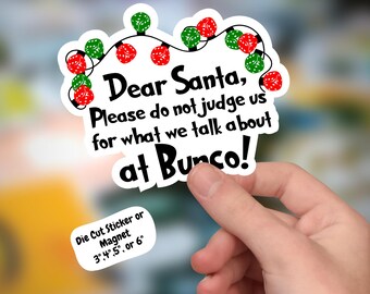 May include: A die-cut sticker or magnet featuring a string of red and green dice lights. The text reads: Dear Santa, Please do not judge us for what we talk about at Bunco! A small white label indicates available sizes of 3, 4, 5, or 6 inches.