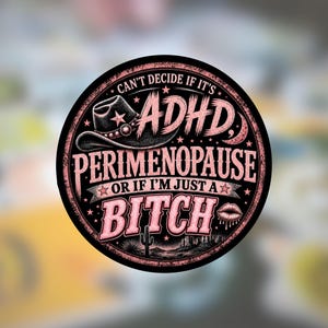 May include: A circular sticker with a black background and pink glitter-style text that reads: CAN'T DECIDE IF IT'S ADHD, PERIMENOPAUSE OR IF I'M JUST A BITCH. The design features a cowboy hat, a crescent moon, a cactus, and a pair of lips.