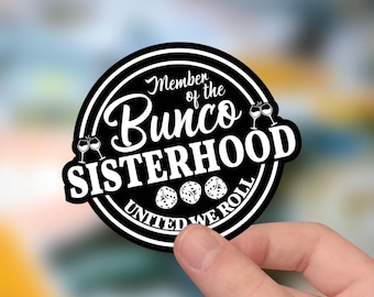 May include: A circular black and white sticker featuring the text Member of the Bunco SISTERHOOD UNITED WE ROLL. The design includes illustrations of two wine glasses and three six-sided dice arranged in a horizontal row within the border.