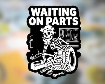 May include: Black and white sticker featuring a skeleton wearing a cap, leaning on a stack of tires, and looking bored. The text "WAITING ON PARTS" is above the skeleton. A toolbox, wrenches, and a tire are also visible.