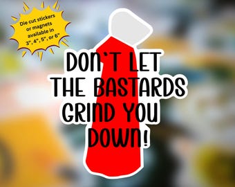 May include: A die-cut sticker or magnet featuring the text "DON'T LET THE BASTARDS GRIND YOU DOWN!" in bold black letters. The design includes a red and white graphic. Available in 3", 4", 5", or 6" sizes.