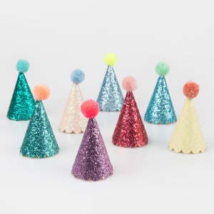 May include: Assortment of eight colorful glitter party hats with pom-poms on top. The hats are in various colors, including teal, pink, purple, red, yellow, and blue.